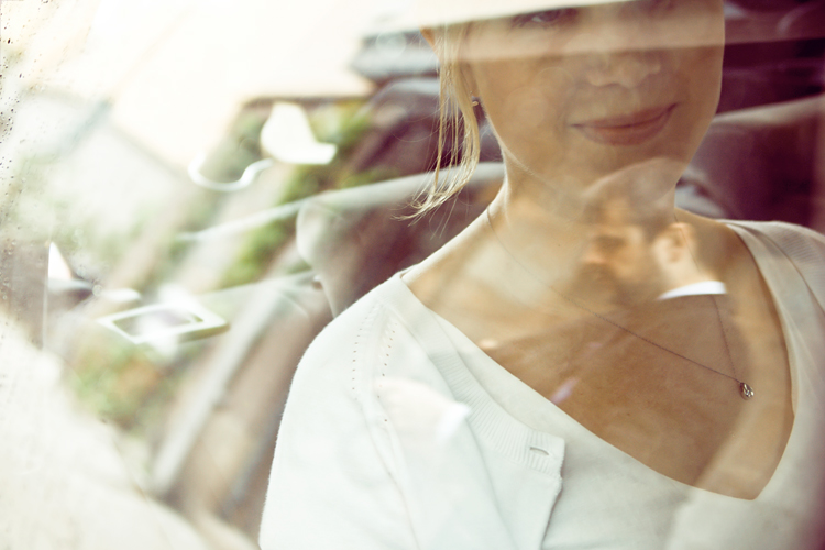 the bride through the car window, with her husband's reflection on top